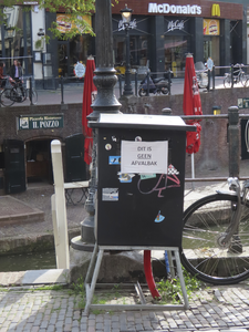 901628 Afbeelding van een meetkastje op de Oudegracht te Utrecht, ter hoogte van de Drieharingstraat, met opgeplakt de ...